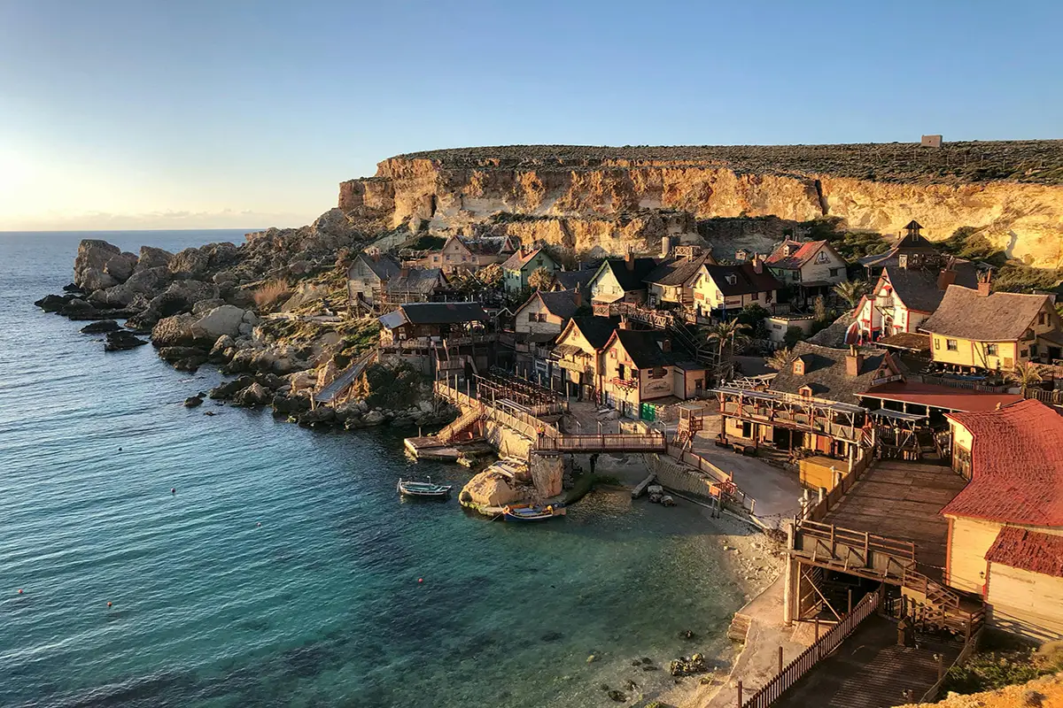 Seaside village with colorful houses by turquoise water.