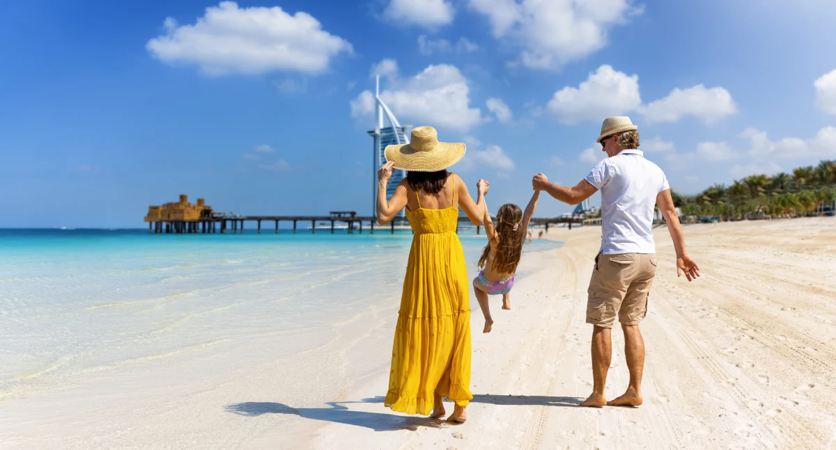 An expat family walks down the beach in Dubai, the UAE, one of the best countries to raise a family.