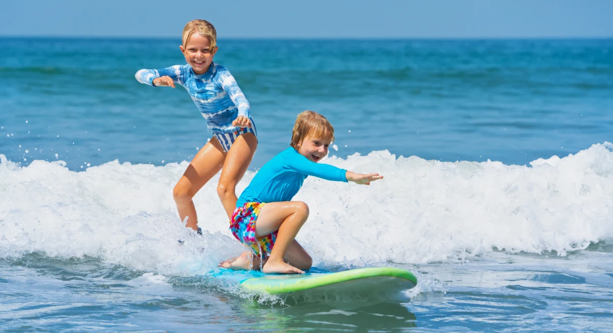 Kids surfing on an Australian beach, one of the best countries to raise a family.