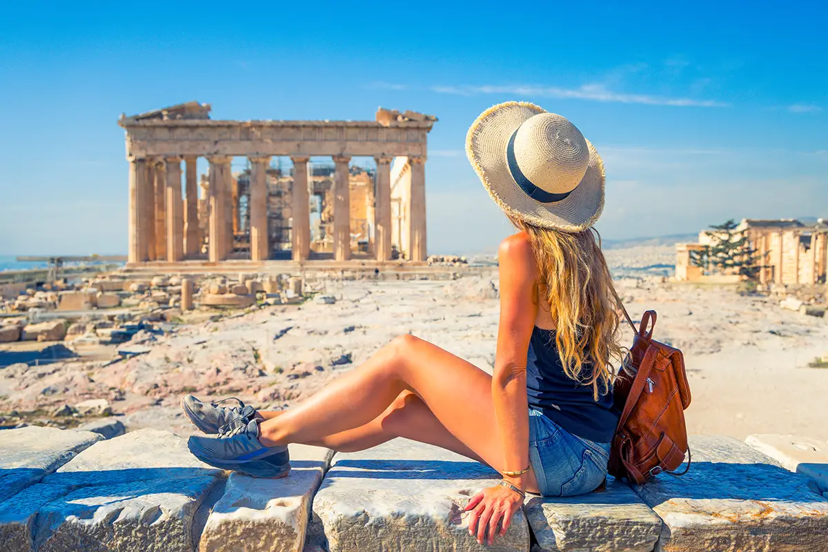 Female tourist sitting next to Parthenon in Athens, Greece