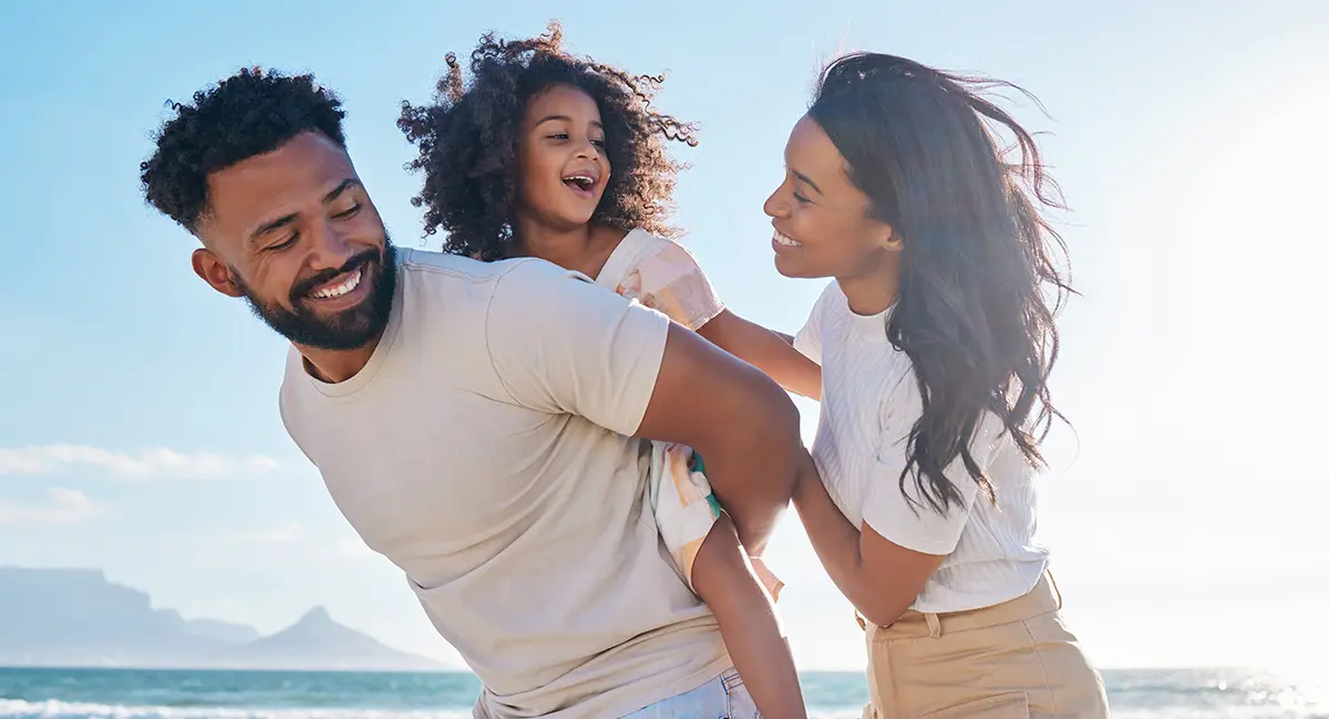 A happy family enjoying their expat life in a warm, sunny country by the beach.